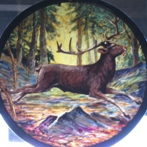 Painted glass roundel. Subject is a stag running in the forest.