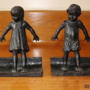 Two bronze bookend figurines. On the left is a young girl, on the right a young boy.