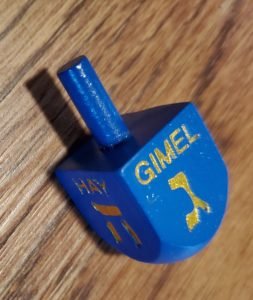 Blue dreidel with "gimel" on top. 