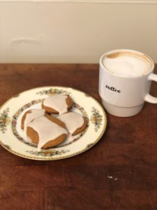 Cookies covered in icing paired with a cup of coffee. 